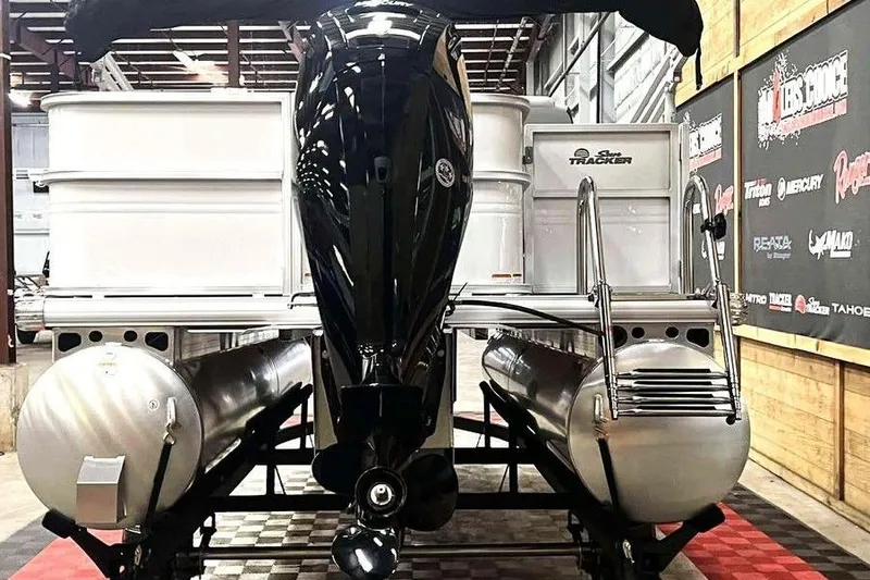 Slide: The Image of 2026 Sun Tracker PARTY BARGE® 18 DLX pontoon boat in showroom, rear view. - 3