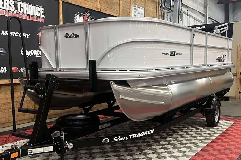 Slide: The Image of 2026 Sun Tracker PARTY BARGE® 18 DLX pontoon boat on display in showroom. - 5