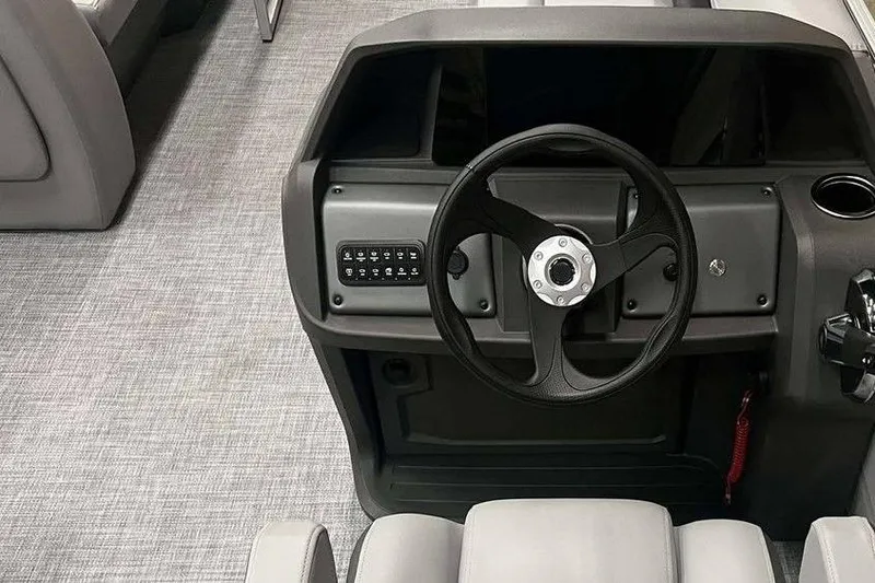 Slide: The Image of 2026 Sun Tracker PARTY BARGE® 18 DLX steering console with modern controls and gray upholstery. - 6