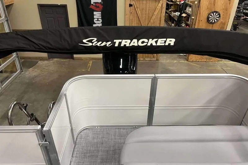 Slide: The Image of 2026 Sun Tracker PARTY BARGE® 18 DLX interior with cover, in a showroom setting. - 7