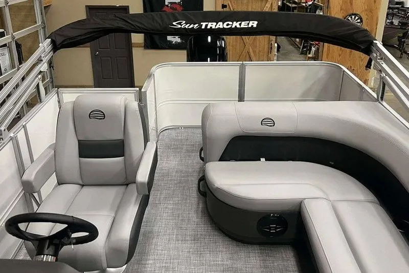 Slide: The Image of 2026 Sun Tracker PARTY BARGE® 18 DLX interior with gray seating and steering wheel. - 8