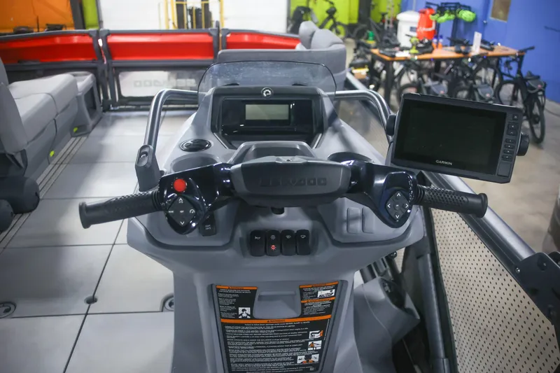 Slide: The Image of 2022 Sea Doo Switch dashboard with steering controls and Garmin display in a showroom. - 12