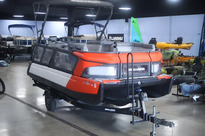 Slide: The Image of 2022 Sea Doo Switch pontoon boat displayed indoors on a trailer. - 4