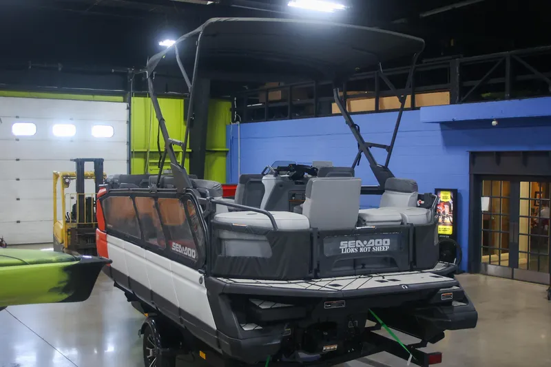 Slide: The Image of 2022 Sea Doo Switch pontoon boat in indoor showroom, featuring modern design and seating. - 7