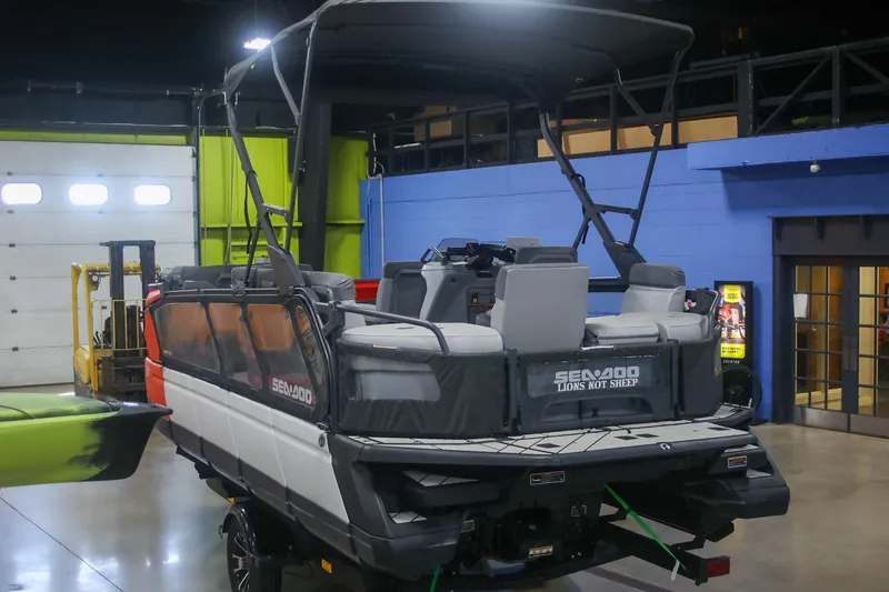 Slide: The Image of 2022 Sea Doo Switch pontoon boat displayed indoors with canopy and seating. - 8