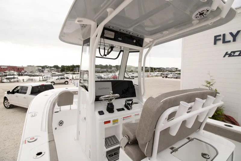 Slide: The Image of 2026 Sea Hunt Gamefish 25 boat interior with Garmin navigation, docked near marina. - 3