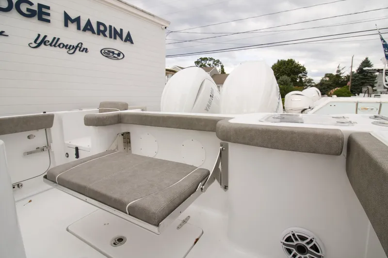 Slide: The Image of 2026 Sea Hunt Gamefish 25 boat interior with cushioned seating at a marina. - 9