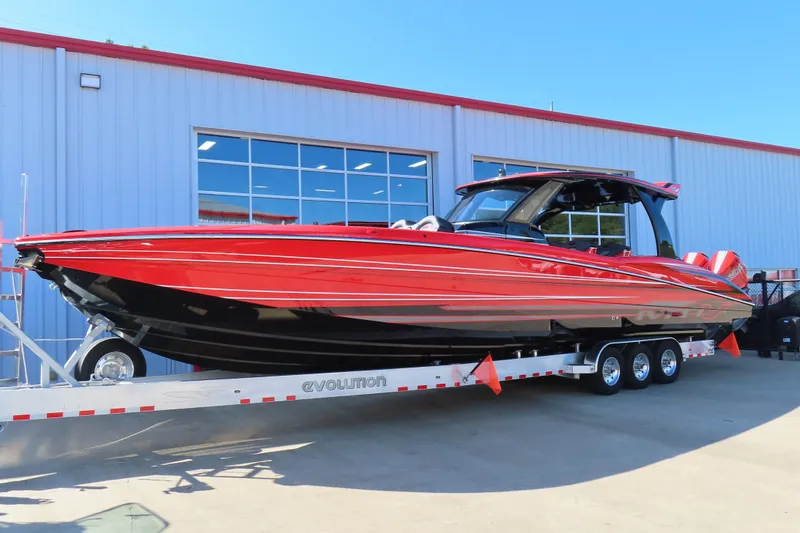 Slide: The Image of Red 2026 MTI 42 v boat on trailer outside a building. - 2