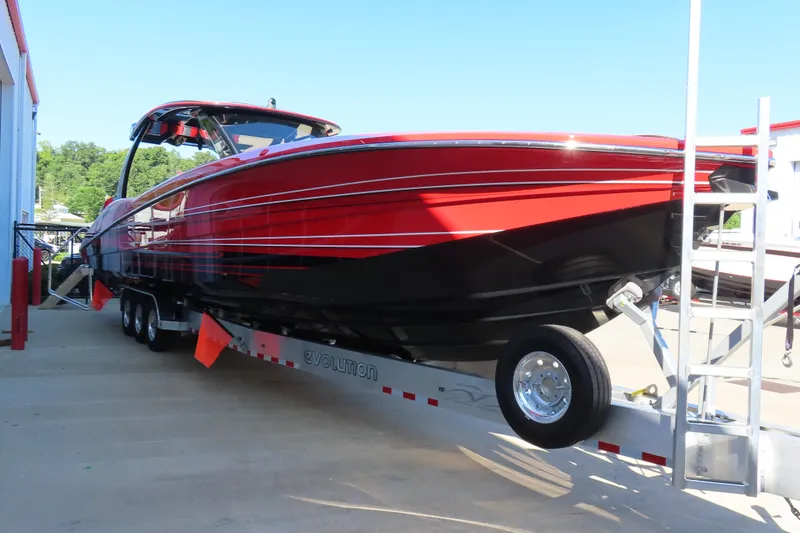 Slide: The Image of Red and black 2026 MTI 42 v boat on trailer, parked outdoors. - 3