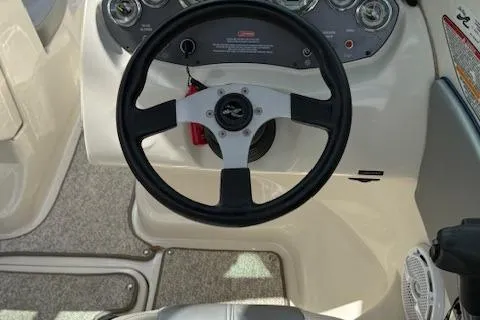 Slide: The Image of Steering wheel of a 2010 Sea Ray 185 Sport boat, featuring a sleek dashboard design. - 4