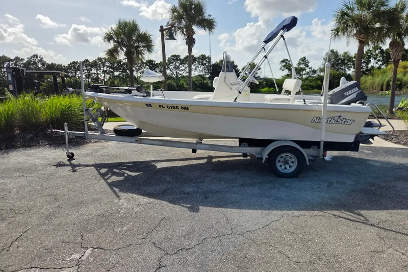 The Image of 2005 NauticStar 1800 Nautic Bay boat on trailer, parked outdoors with palm trees. - 0