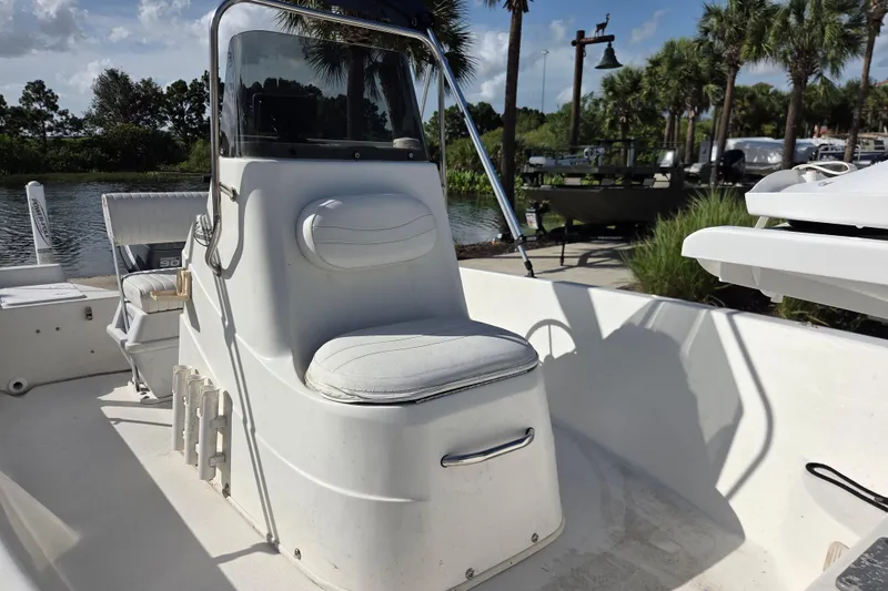Slide: The Image of 2005 NauticStar 1800 Nautic Bay boat interior with seating and console, docked near palm trees. - 5