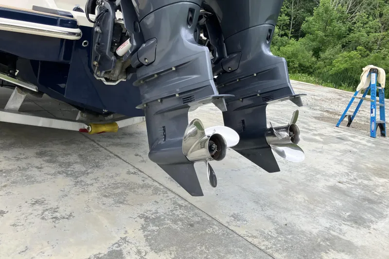 Slide: The Image of Twin outboard motors on a 2021 Scout 255 Dorado boat, parked on concrete. - 5