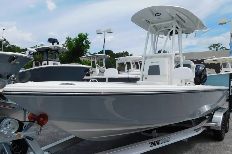 The Image of 2026 Pathfinder 2200 TRS boat on trailer, displayed outdoors with other boats. - 0