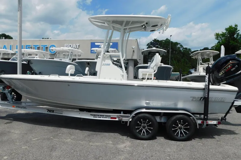 Slide: The Image of 2026 Pathfinder 2200 TRS boat on trailer at dealership, side view. - 2