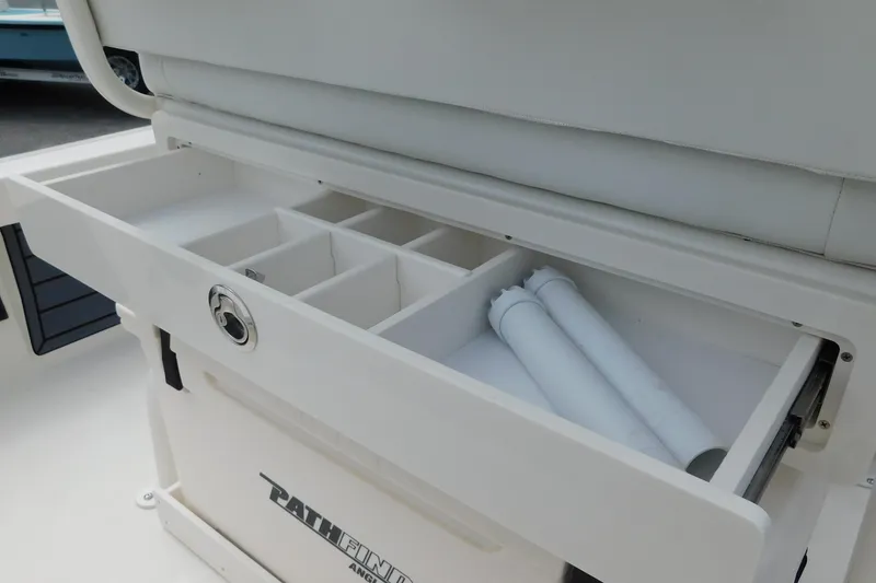 Slide: The Image of 2026 Pathfinder 2200 TRS boat storage compartment with organized sections and secure latch. - 27