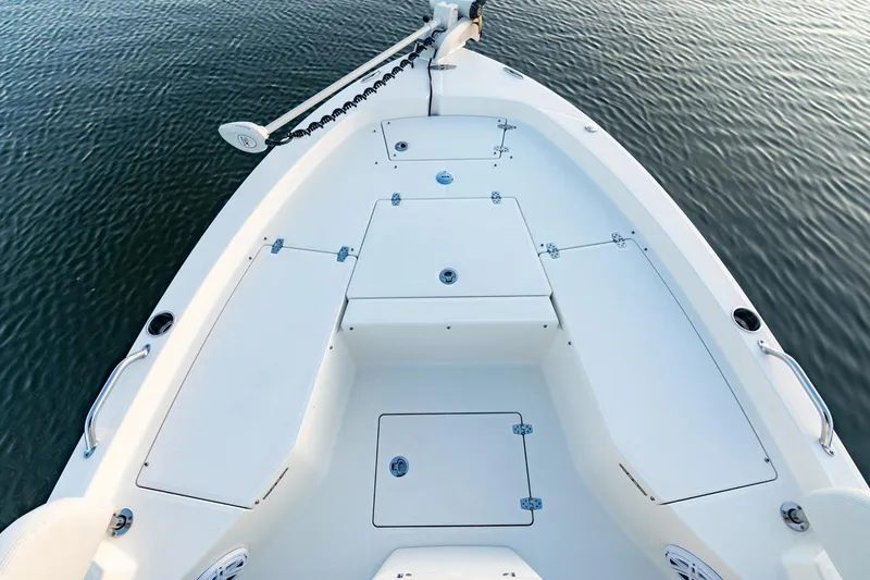 Slide: The Image of 2026 Pathfinder 2200 TRS boat deck, featuring storage compartments and sleek design on calm water. - 37