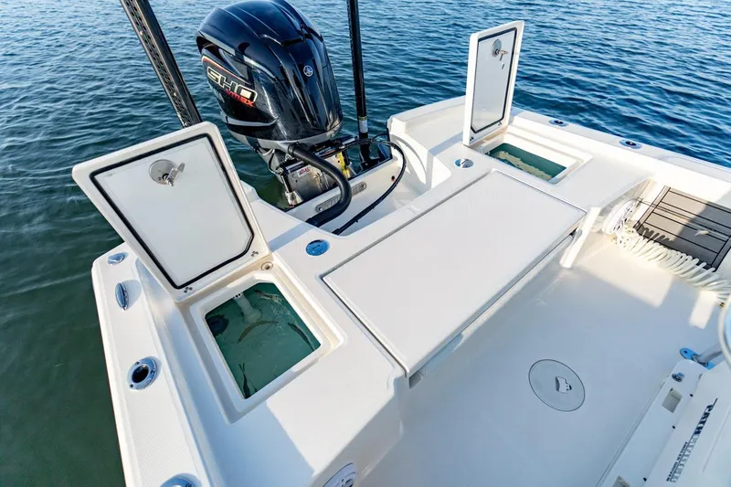 Slide: The Image of 2026 Pathfinder 2200 TRS boat with open storage compartments and outboard motor on water. - 38