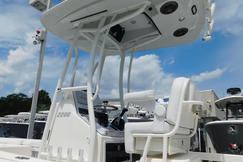 Slide: The Image of 2026 Pathfinder 2200 TRS boat with T-top and seating, under a clear blue sky. - 4