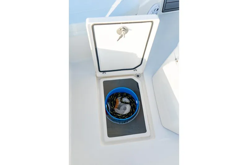 Slide: The Image of Open storage compartment on 2026 Pathfinder 2200 TRS boat with blue bucket inside. - 43