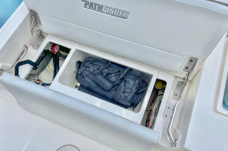 Slide: The Image of Open storage compartment on 2026 Pathfinder 2200 TRS boat with gear bag inside. - 48