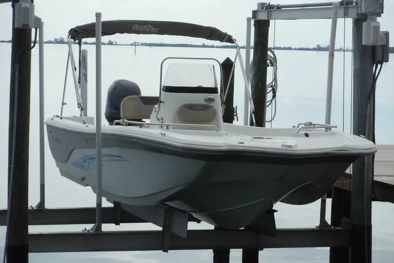 Slide: The Image of 2014 NauticStar 210 Angler boat on lift by the water. - 11