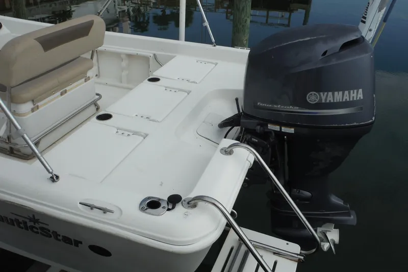 Slide: The Image of 2014 NauticStar 210 Angler boat with Yamaha outboard motor, docked at marina. - 13