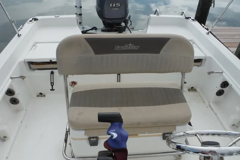 Slide: The Image of 2014 NauticStar 210 Angler boat interior with seating and steering wheel. - 17