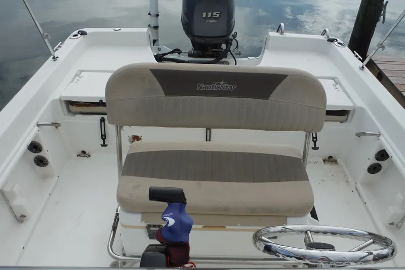 Slide: The Image of 2014 NauticStar 210 Angler boat interior with seating and steering wheel. - 20