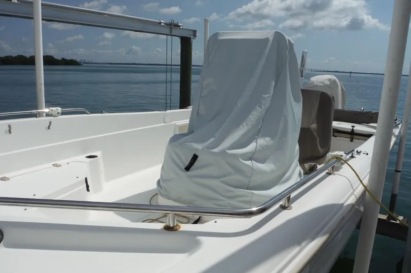 Slide: The Image of 2014 NauticStar 210 Angler boat with covered seating, docked by calm waters. - 34
