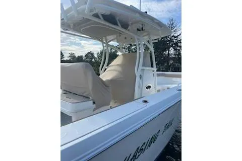 Slide: The Image of 2017 Sailfish 320 CC boat with covered seating, docked on a calm waterway. - 2