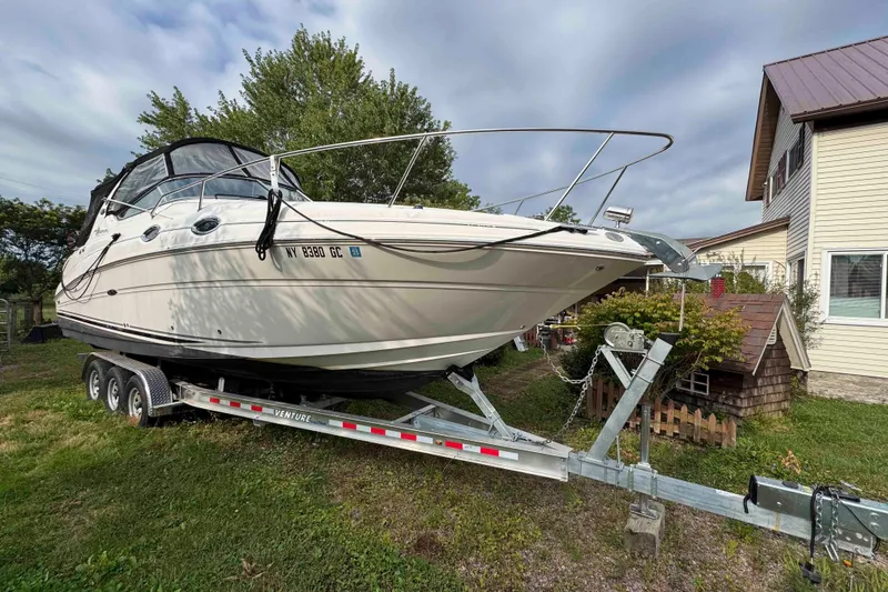 Slide: The Image of 2007 Sea Ray 280 Sundancer boat on trailer, parked near a house. - 1