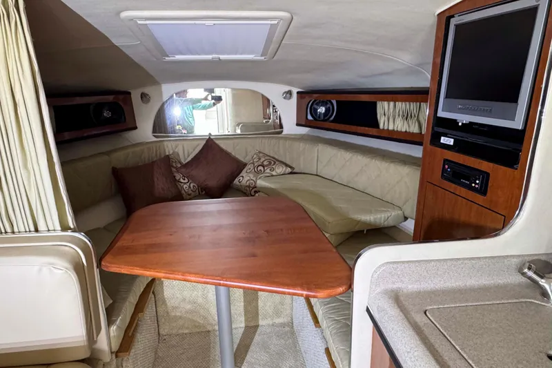 Slide: The Image of 2007 Sea Ray 280 Sundancer cabin interior with seating, table, and entertainment system. - 12
