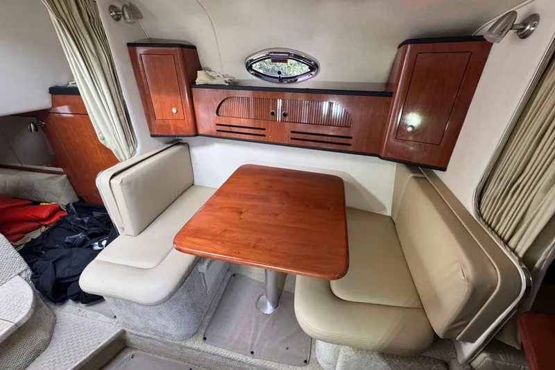 Slide: The Image of 2007 Sea Ray 280 Sundancer cabin with wooden table and beige seating. - 15