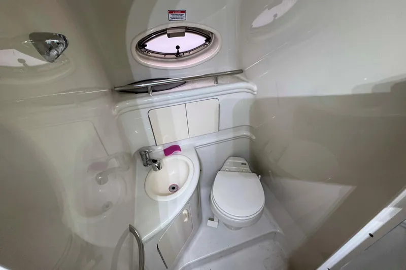 Slide: The Image of Compact bathroom in 2007 Sea Ray 280 Sundancer boat, featuring sink and toilet. - 16