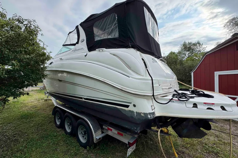 Slide: The Image of 2007 Sea Ray 280 Sundancer boat on trailer, parked near red barn and trees. - 2