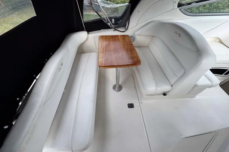 Slide: The Image of 2007 Sea Ray 280 Sundancer interior with white seating and wooden table. - 7