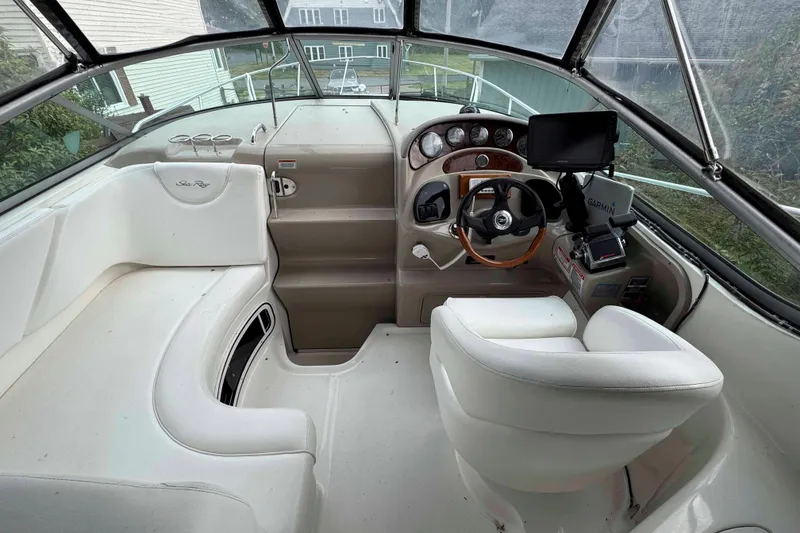 Slide: The Image of 2007 Sea Ray 280 Sundancer cockpit with steering wheel, navigation system, and white seating. - 8