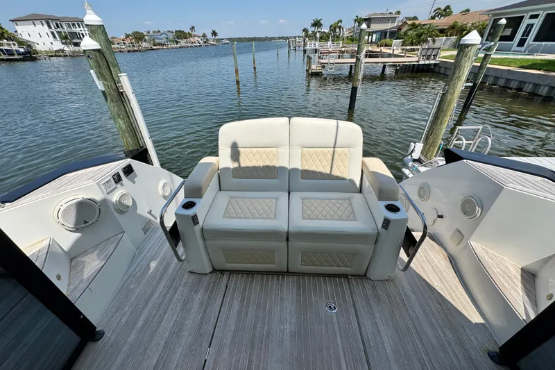 Slide: The Image of Luxury seating on 2018 Beneteau Gran Turismo 46 yacht, docked by waterfront homes. - 11