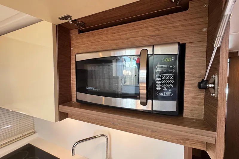 Slide: The Image of Microwave in 2018 Beneteau Gran Turismo 46 yacht kitchen, featuring modern wood cabinetry. - 30