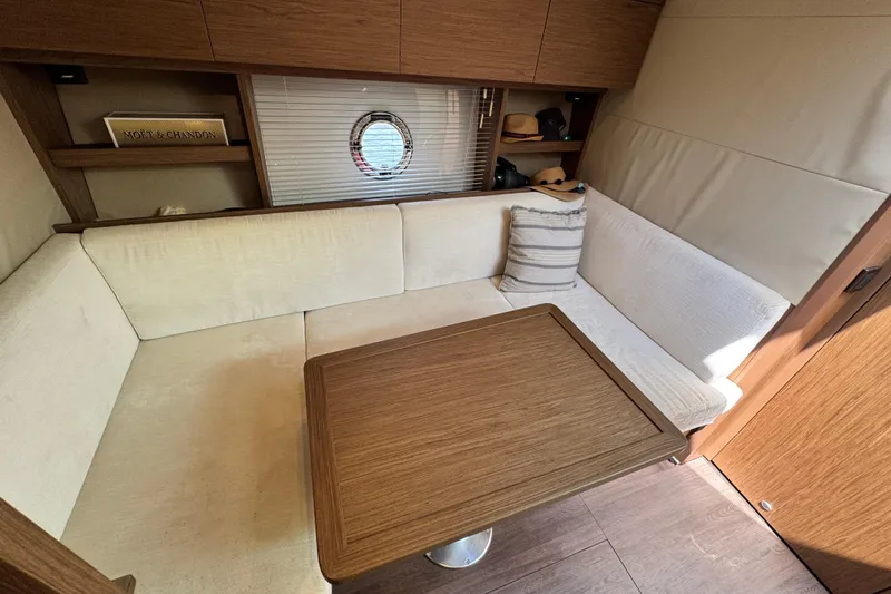 Slide: The Image of Interior of 2018 Beneteau Gran Turismo 46 yacht with cozy seating and wooden table. - 32