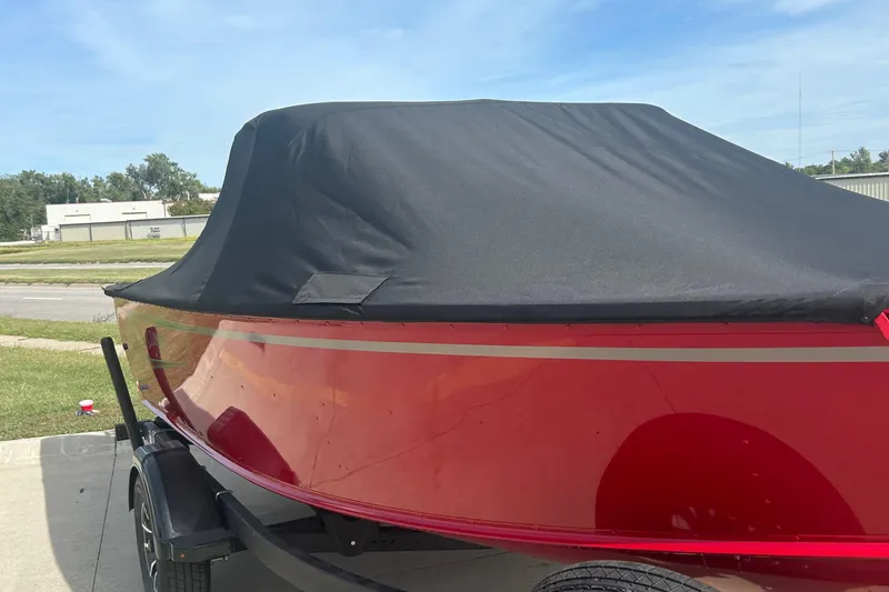 Slide: The Image of 2026 Lund 1800 Explorer Sport boat with black cover, parked outdoors. - 3