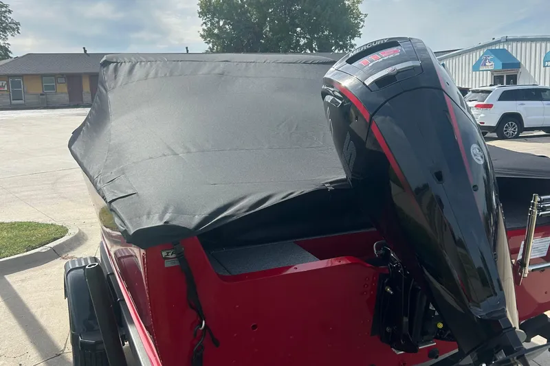 Slide: The Image of 2026 Lund 1800 Explorer Sport boat with Mercury outboard motor, covered and parked outdoors. - 4