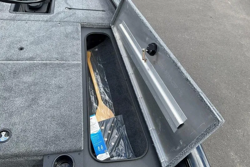 Slide: The Image of 2025 Tracker Pro Team 175 boat storage compartment with paddle and accessories. - 22