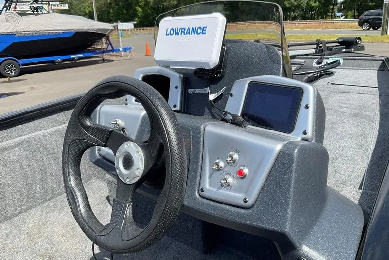 Slide: The Image of 2025 Tracker Pro Team 175 boat dashboard with steering wheel and navigation system. - 27