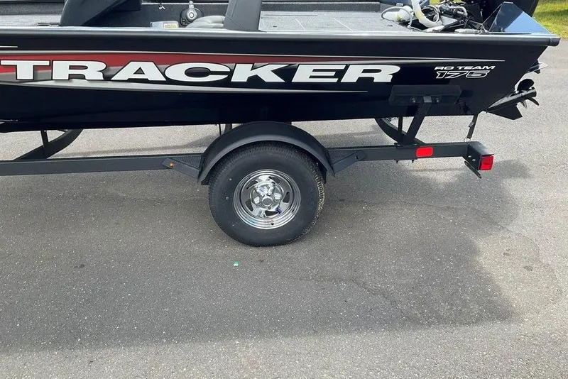 Slide: The Image of 2025 Tracker Pro Team 175 boat on trailer, side view, parked on asphalt. - 35