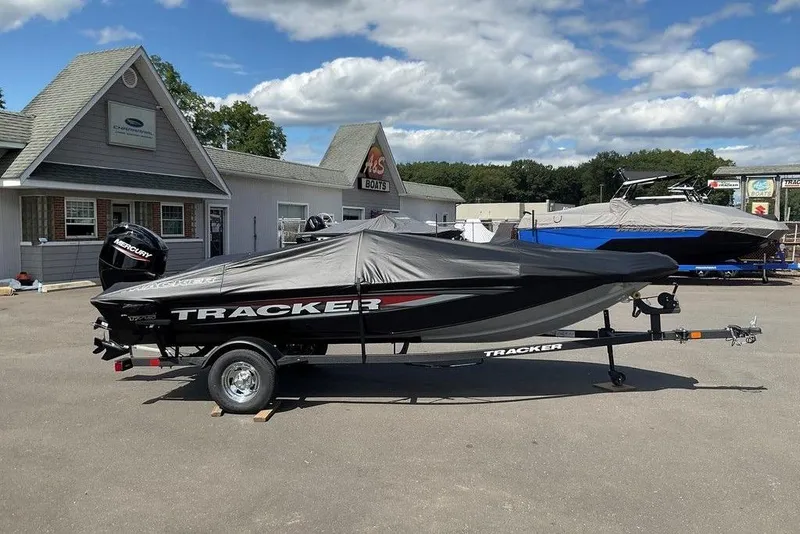 Slide: The Image of 2025 Tracker Pro Team 175 boat covered on trailer, parked outside dealership. - 36