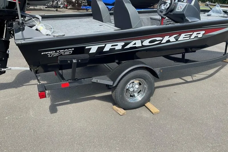 Slide: The Image of 2025 Tracker Pro Team 175 boat on trailer, black with red accents, parked on pavement. - 38