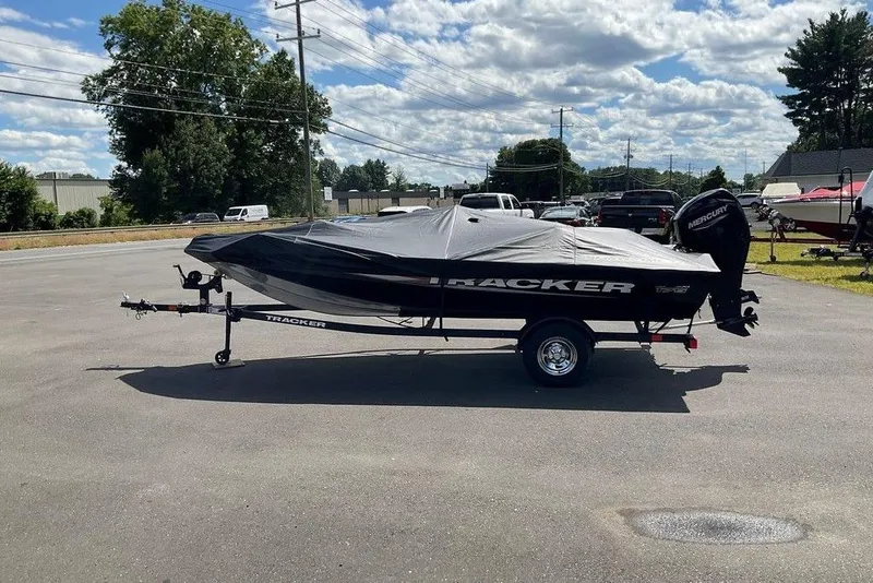 Slide: The Image of 2025 Tracker Pro Team 175 boat on trailer, covered, in parking lot under cloudy sky. - 39