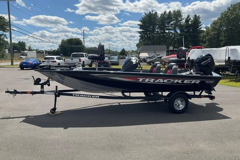 Slide: The Image of 2025 Tracker Pro Team 175 boat on trailer, parked outdoors under a cloudy sky. - 6